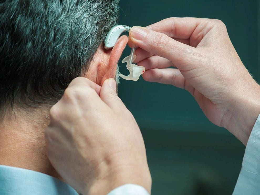 A man putting on an ear piece