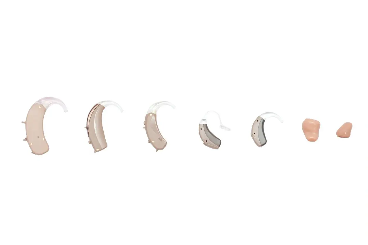 A series of different shapes and sizes of hearing aids.